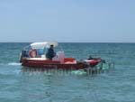 Un bateau avec des gros râteaux, qui libére l'eau de la proximité de la plage des ordures