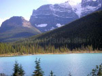 Türkisfarbener See vor den Gipfeln eines schneebedeckten Bergriesen in den Rocky Mountains