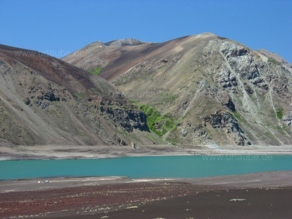 Asche, die Lagune und die trockene Gebirgskette. Ein paar Kilometer weiter befindet sich bereits Argentinien.