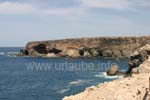 Blick auf die Bucht Caleta Negra mit den dunklen Felswänden und Höhlen