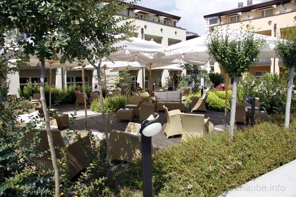 Gem&uuml;tliche Sessel und Sofas im Freien vor der Hotelbar