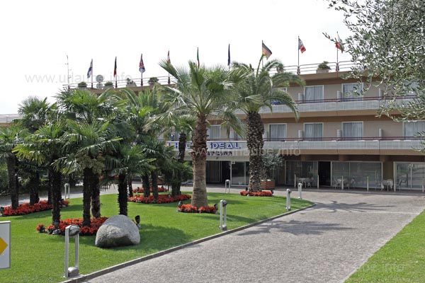 Das Gel&auml;nde des Hotel Ideal ist mit Palmen, Olivenb&auml;umen und Blumenbeeten sch&ouml;n bepflanzt.