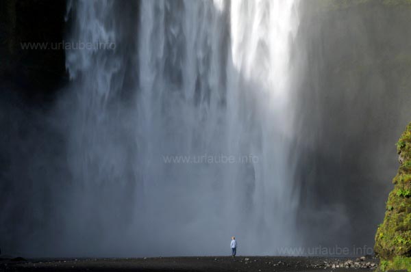 Kleiner Mensch vor gro&szlig;em Wasserfall