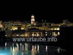 Hotelanlage mit Kirchturm und Pool bei Nacht