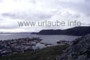 Von der Anhöhe über Honningsvag der Blick auf den südöstlichen Küstenverlauf der Nordkapinsel Mageröy. Links im Bild, am Horizont und weiter im Süden, das Festland mit der Halbinsel Porsanger. Dort beginnt der 8,6 km lange Untersee-Tunnel, der seit 1999 Mageröy mit dem Festland verbindet.