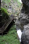 Auf einer steilen Holztreppe geht es auf einen Felsen hinauf.